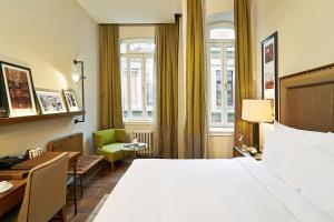 a hotel room with a large bed and a green chair at The Bank Hotel Istanbul, a Member of Design Hotels in Istanbul +130 photos