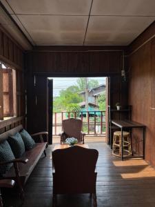 a living room with a couch and a table at Me Vadsana Homestay in Ban Mae Khachan (1)