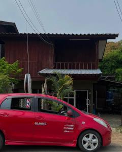 a red car parked in front of a house at Me Vadsana Homestay in Ban Mae Khachan (1)