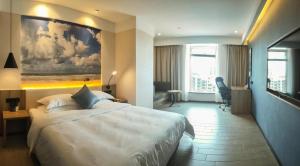 a hotel room with a bed and a painting on the wall at hailihotel in Dongguan +37 photos