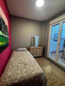 Un dormitorio con una cama y una ventana grande. en El apartamento verde, en Ayamonte