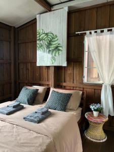 two beds in a room with wooden walls at Me Vadsana Homestay in Ban Mae Khachan (1)