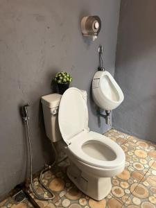 a bathroom with a toilet and a sink at Me Vadsana Homestay in Ban Mae Khachan (1)
