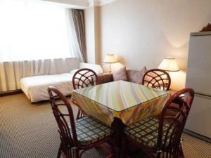 a room with a table and chairs and a bed at Kunming Hotel in Kunming