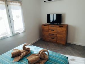 a bedroom with towels on a bed with a television at Paradis Calpe in Calpe