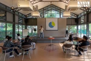 a group of people sitting in a room with a presentation at Nivaant Farms by StayVista - Green Retreat with Pool, Orchard, Jacuzzi & Gazebo in Karjat +64 photos