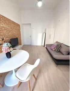 a living room with a white table and a couch at Petite Deva - Central loft with balcony in Cagliari