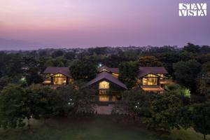 eine Luftansicht eines Hauses in der Nacht in der Unterkunft Nivaant Farms & Cottages - Nestled in lush greenery, offering a Swimming pool, Orchard, Jacuzzi & A spacious lawn with gazebo in Karjat