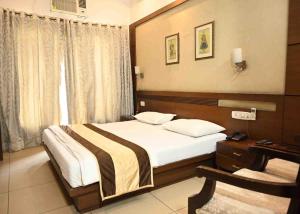 a bedroom with a bed and a table and a window at Phoenix Hospitality in Gurgaon +14 photos