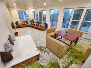 Una sala de estar con sofás y una mesa. en Soni's Mansion-800m from Khajuraho Temples, en Khajurāho