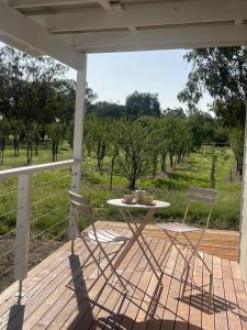 a patio with a table and chairs on a porch at Dalton Farmstay in Ulupna West