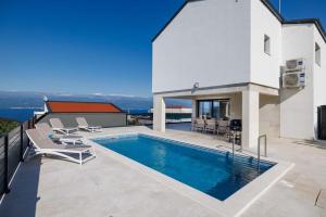 a house with a swimming pool on a roof at Villa SUNSET II with private pool and beautiful sea view in Vrbnik