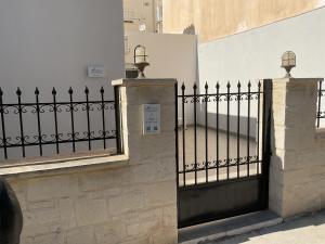 a black wrought iron fence next to a building at Maria's Dream House in Ierapetra
