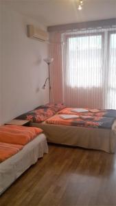 ブダペストにあるJudit Apartmanokのベッドルーム1室(ベッド2台、ランプ、窓付)