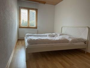 ein weißes Schlafzimmer mit einem Bett in einem Zimmer in der Unterkunft Small paradise in Menznau