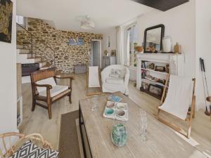 a living room with a table and chairs and a brick wall at Maison avec jardin pour 4 adultes et 2 enfants in Beg-Meil