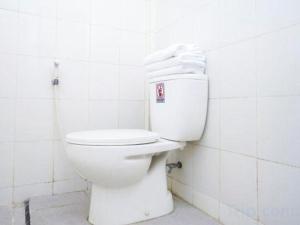 a white toilet in a white tiled bathroom at OYO 2003 Female Guest House in Probolinggo +63 photos