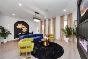 a living room with a blue couch and yellow chairs at The Prolific Stay - Where Luxury Meets Lifestyle in Houston