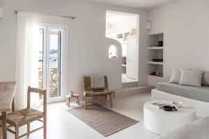 a white living room with a couch and a table at Om Living Milos in Pollonia