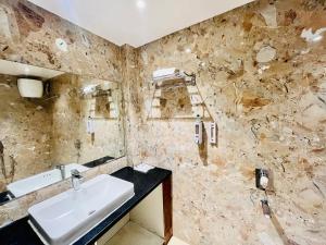 un bagno con lavandino e specchio di Shankar Bhavan By Vinayak Hotels a Brahmapur