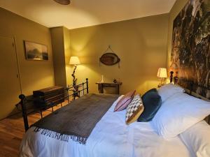 a bedroom with a large bed with white sheets and pillows at Le gîte de Pierrot in Thoré-la-Rochette