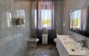 a white bathroom with a sink and a toilet at Fontana Oasis Apartments in Castelnuovo del Garda +46 photos