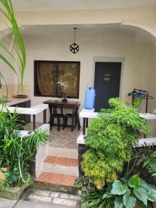 长滩岛Tara staycation unit的庭院设有2个白色长椅和桌子