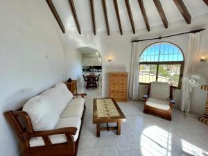 a living room with a white couch and a table at Villa June in Benitachell