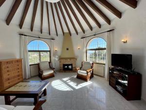 a living room with two chairs and a tv at Villa June in Benitachell