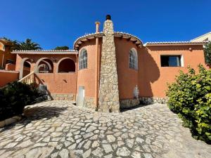 a house with a stone driveway in front of it at Villa June in Benitachell