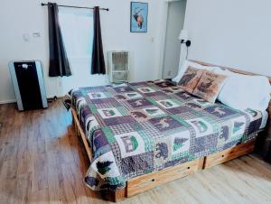 a bedroom with a bed with a quilt on it at Fox n Bear Cottages Big Bear in Big Bear Lake