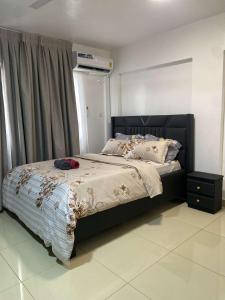 a bedroom with a large bed with a black headboard at Adiepena Cozy Apartment- 5mins from KNUST & 7mins from Kumasi Airport in Kumasi