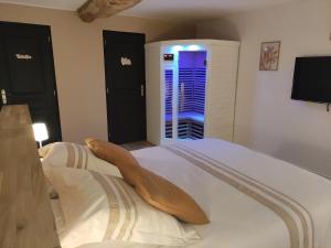 a bedroom with a bed with white sheets and a window at La vie est belle in Domjean