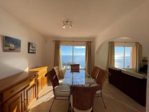 een eetkamer met een glazen tafel en stoelen bij Atico Vistamar X2113 in Benitachell