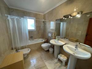 een badkamer met 2 wastafels, een toilet en een bad bij Atico Vistamar X2113 in Benitachell +21 foto's