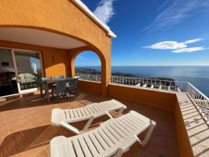 een balkon met stoelen en een tafel en de oceaan bij Atico Vistamar X2113 in Benitachell