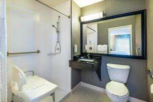 a bathroom with a toilet and a sink and a mirror at Comfort Inn Gatineau in Gatineau