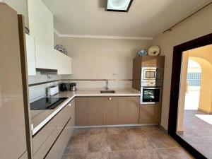 ベニタチェルにあるVilla Paraísoの白いキャビネットとコンロ付きオーブンを備えたキッチン