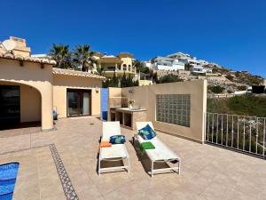 ベニタチェルにあるVilla Paraísoの家の上に椅子2脚とテーブル付きのパティオ