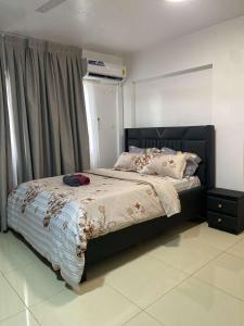 a bedroom with a large bed with a black headboard at Adiepena Cozy Apartment- 5mins from KNUST & 7mins from Kumasi Airport in Kumasi
