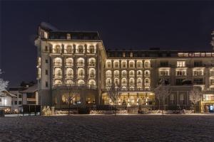 un grande edificio illuminato di notte di Kempinski Palace Engelberg a Engelberg