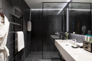 a bathroom with two sinks and a large mirror at Kempinski Palace Engelberg in Engelberg