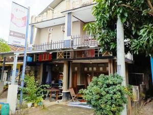a building with a balcony and a table in front of it at Lishafa Homestay in Karimunjawa