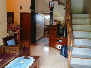 a living room with a staircase and a tv at Lishafa Homestay in Karimunjawa