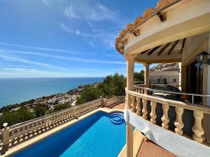 ベニタチェルにあるVilla Karinaのバルコニーにプールがある家