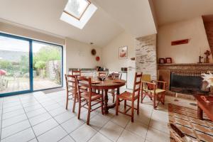 une salle à manger avec une table et des chaises et une cheminée dans l'établissement Maison pour 6 adultes - 2 enfants avec jardin, à Saint-Gildas-de-Rhuys 15 autres photos