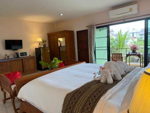 a bedroom with a large bed with two stuffed animals on it at Laph Kham House in Chiang Mai