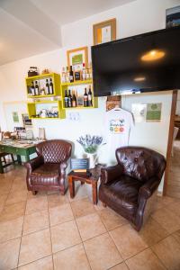 a living room with two leather chairs and a flat screen tv at Guesthouse Green Istria in Truške