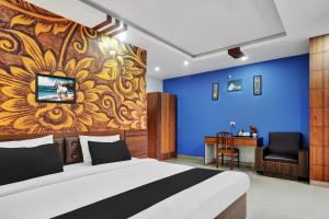 a bedroom with a bed and a blue wall at Super Townhouse Zoo Road Near Guwahati Central Formerly IR Luxuria in Guwahati