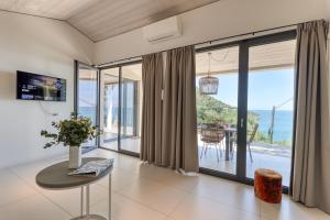 a living room with a table and a view of the ocean at Villaggio Balzi Rossi in Ventimiglia